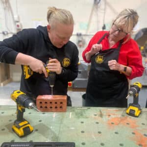 Sarah-showing-student-drilling-into-a-brick