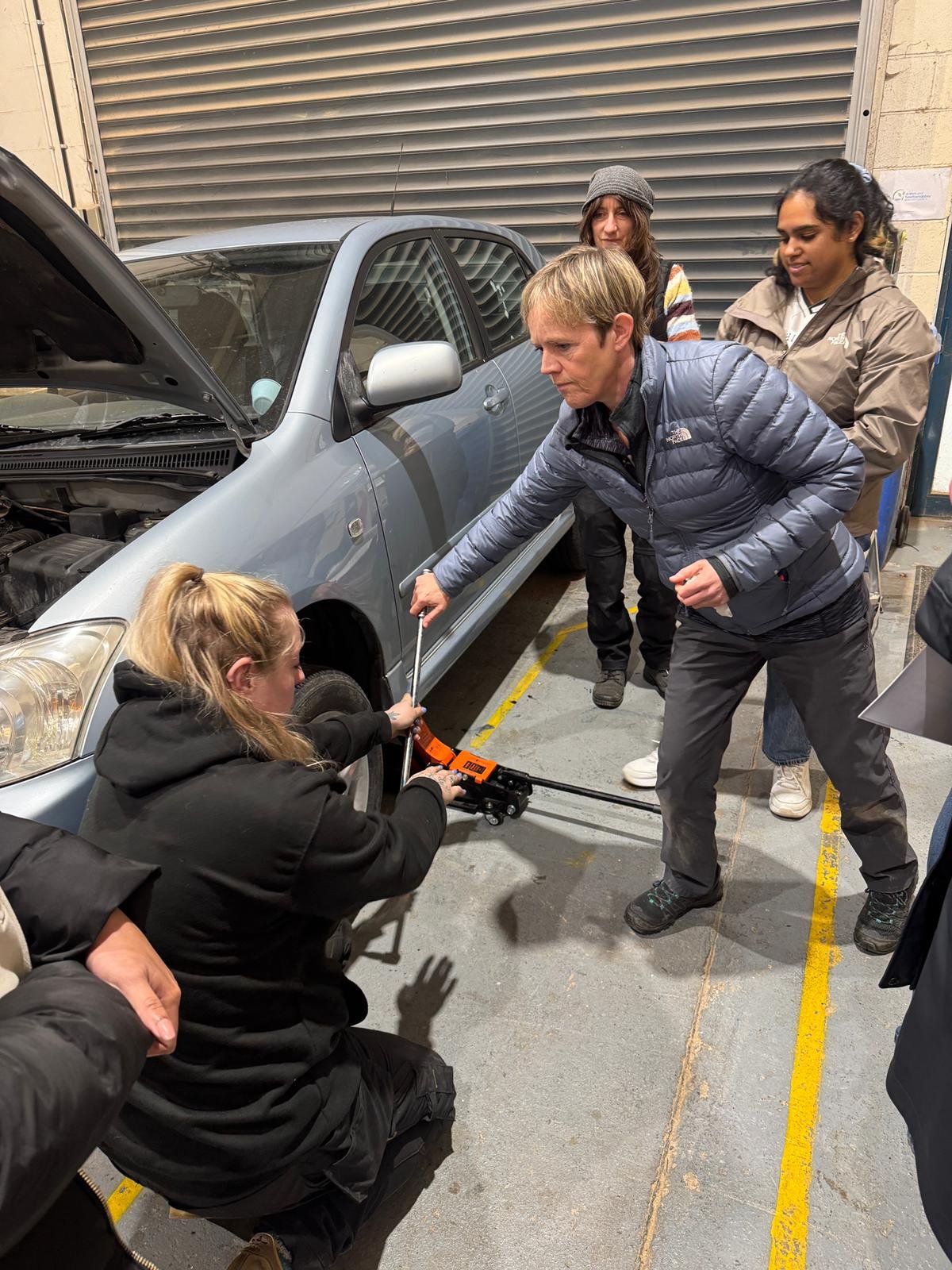 Participant learning practical car maintenance skills